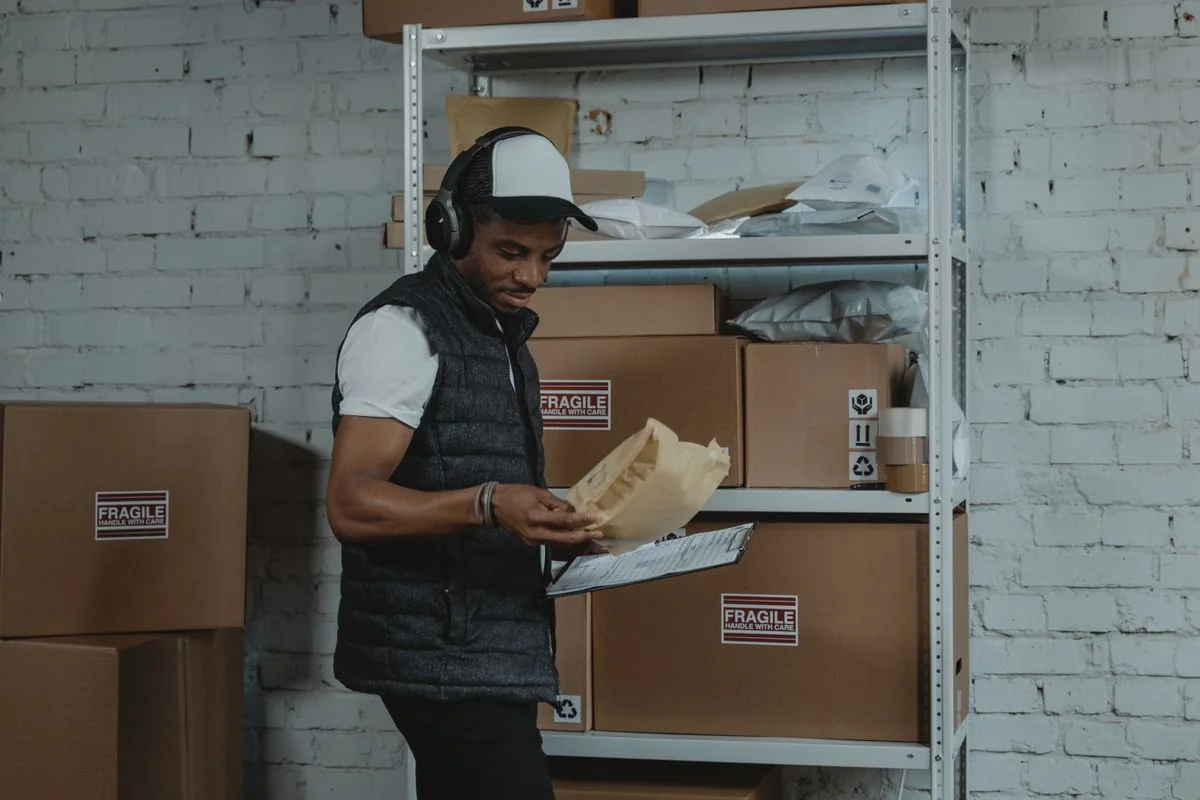 Warehouse worker reviewing a parcel in an industrial storage area